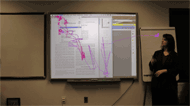 A picture of a video screen showing a software demonstration, with a sign language Interpreter. Eye-tracking cues are overlaid on the screen. The hearing student's eye movements stays on the demonstration focus, while the deaf students's eye-movements are scattered all over, looking for the slide focus